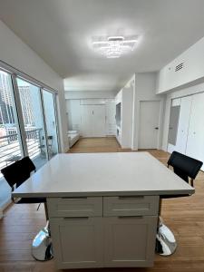 an empty room with a large white table and chairs at Fully Equipped Modern Loft in the heart of Miami in Miami
