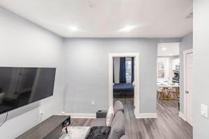 a white living room with a large flat screen tv at Prime Location Explore NYC in West New York