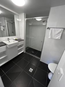 a bathroom with a shower and a sink at Aruba Beach Resort in Gold Coast