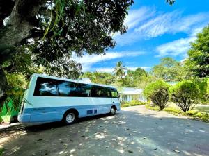 a blue and white bus parked in a driveway at Fortuna Bungalows in Kandy