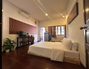 a bedroom with a bed and a table with a desk at INCM Guesthouse in Chiang Mai
