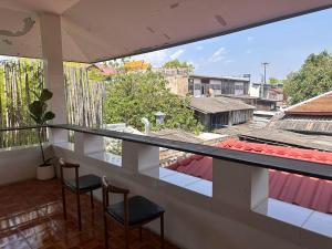 a balcony with chairs and a view of a city at INCM Guesthouse in Chiang Mai