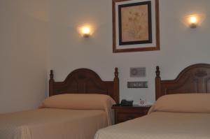 A bed or beds in a room at Hotel Heredero