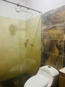 a bathroom with a toilet and a glass shower at Hermosa Casa de descanso Villa María in Don Matías