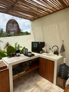 a kitchen with a counter with a sink and a tv at Turtle Villa 2 in Kuta Lombok
