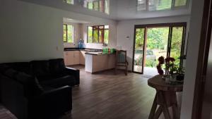 a living room with a couch and a kitchen at Eco Retiro La Paz in Vergara