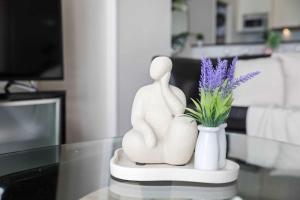 una estatua de pareja sentada en una mesa con un jarrón con flores en Cozy 2BR Apartment Steps from Darling Harbour, en Sídney