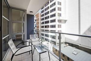 - Balcón con 2 sillas y mesa de cristal en Cozy 2BR Apartment Steps from Darling Harbour, en Sídney 11 fotos más
