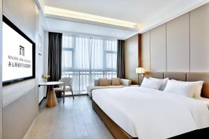 Postel nebo postele na pokoji v ubytování Zhoushan Maison New Century Hotel