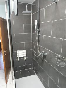a bathroom with a shower with a gray tiled wall at Pension Mahler wir sind günstig, zwischen Wittenberge, Perleberg, Kyritz, Heiligengrabe, Pritzwalk, Putlitz, Wittstock, , an der A 24 in Kuhbier +26 photos