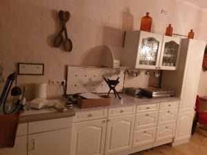 a kitchen with white cabinets and a counter top at Pension Mahler wir sind günstig, zwischen Wittenberge, Perleberg, Kyritz, Heiligengrabe, Pritzwalk, Putlitz, Wittstock, , an der A 24 in Kuhbier