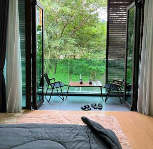 a room with a large window with a table and chairs at luxurious villa templer park in Rawang