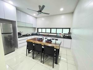 a kitchen with a wooden table and black chairs at luxurious villa templer park in Rawang
