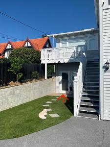a small yard with a white staircase and a house at Central, secure and upmarket Auckland in Auckland
