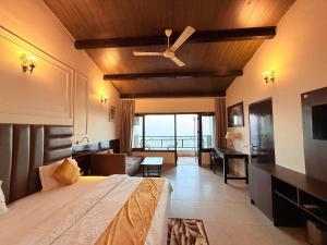Cette chambre comprend un lit et un ventilateur de plafond. dans l'établissement ECKO Kasang Regency Hill Resort, à Lansdowne
