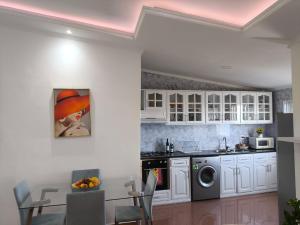 a kitchen with white cabinets and a washer and dryer at Old Town view Apartment in Cidade Velha