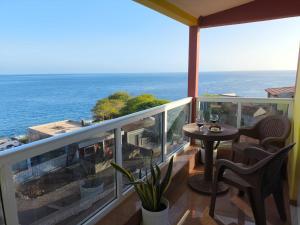 a balcony with a table and chairs and the ocean at Old Town view Apartment in Cidade Velha