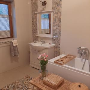 a bathroom with a tub and a sink and a vase of flowers at Villa of Roses in Lanckorona +42 photos