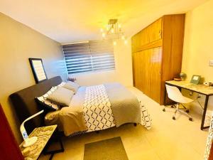 グアダラハラにあるUpdated Modern Condo in Central Locationのベッドと机が置かれた寝室