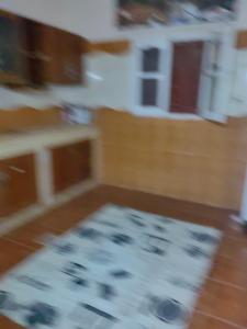 a kitchen with a rug on a wooden floor at travel adventures  +5 photos