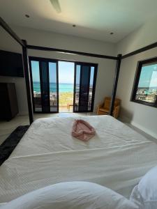 a bedroom with a bed with a pink towel on it at White Sky Beach Villas in Culloden