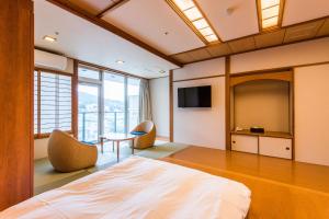 Una televisión o centro de entretenimiento en Ooedo Onsen Monogatari Premium Ito Hotel New Okabe