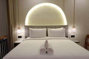 Un dormitorio con una cama con dos zapatos blancos. en Modern loft by Samas Group, en Dalung