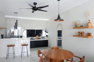 cocina con mesa y ventilador de techo en Modern loft by Samas Group, en Dalung