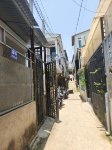 an alley with an iron gate next to a building at Nhà du lịch nguyên căn in Khu Chi Lăng