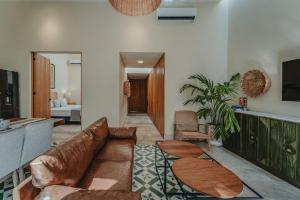una sala de estar con un sofá y una mesa en Casa Mara Reforma con alberca, en Mérida