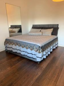 a large bed in a room with a mirror at Luxappart in Luxembourg