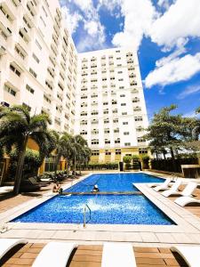 a swimming pool in front of a large building at JFam Suites, C3-3N Studio, Up To 4 Pax in Biñan