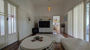 a living room with a tv and a table at Yamba Somerset Cottage in Yamba