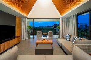 un salon avec un canapé et une télévision dans l'établissement The Line Villas Canggu, à Canggu