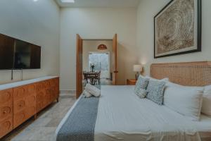 Un dormitorio con una cama grande y un televisor de pantalla plana. en Casa Mara Reforma con alberca, en Mérida 31 fotos más