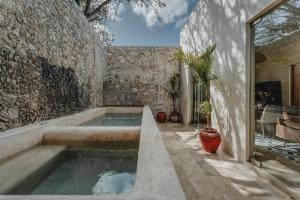 una piscina en la parte lateral de un edificio de piedra en Casa Mara Reforma con alberca, en Mérida