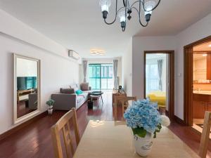 een woonkamer met een bank en een vaas met blauwe bloemen bij Tyms 2BR Apt Near ITC Xujiahui Line1 11 in Shanghai