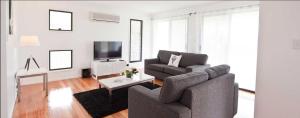 un soggiorno con divano, sedia e TV di Sanctuary by Sirromet a Mount Cotton