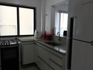 uma cozinha com um lavatório e um frigorífico em Apartamento 2 Quartos Vista Mar em Ubatuba