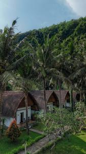 a row of cottages with palm trees at Crystal Bay Villa in Nusa Penida