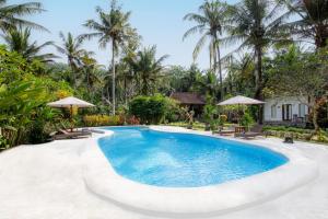 a swimming pool at a resort with palm trees at Crystal Bay Villa in Nusa Penida