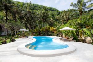 a pool at a resort with trees in the background at Crystal Bay Villa in Nusa Penida