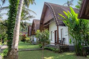 a cottage with a garden and palm trees at Crystal Bay Villa in Nusa Penida