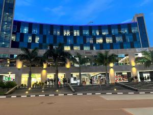 キガリにあるAffordable Luxury Studio with Free Pool, Gym and Office next to Convention Centerのヤシの木が前に生えている大きな建物