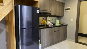 a stainless steel refrigerator in a small kitchen at Apartemen 69m 2 Kamar Tidur dan 2 Kamar Mandi Pemandangan Kota in Medan
