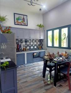 a kitchen with blue cabinets and a table in it at House in Cái Răng