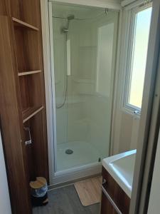 a bathroom with a shower with a glass shower backdoor at Mobil Home climatisé 3 chambres - Parc des 7 fonts in Agde +7 photos