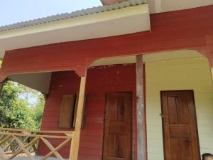 two doors on a red house with a porch at The last Resort in Ban Donsôm