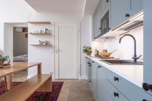 a kitchen with white cabinets and a sink and a table at Stunning Loft with Water View & Free Garage Parking in Kuopio +27 photos