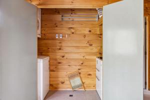 ein Waschraum mit Holzwänden und einer Waschmaschine und einem Trockner in der Unterkunft Bimberdong House in Crackenback + 36 Fotos
